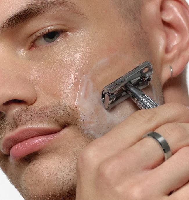 Man shaving with RAWDOG Hydrating Facial Cleanser as shave cream