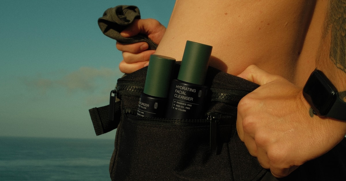 RAWDOG cleanser and moisturizer packed in a black bag by the ocean