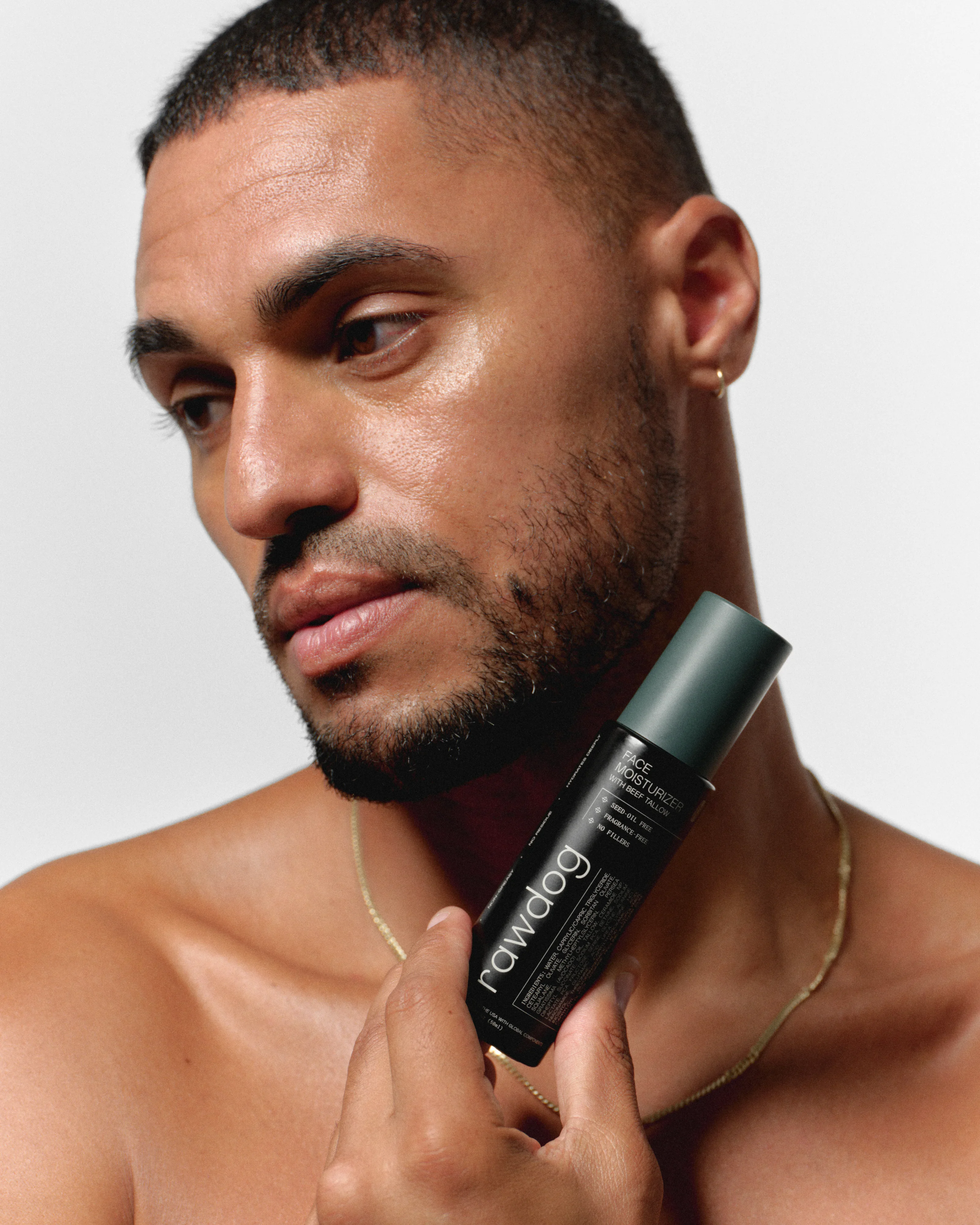 Man holding the RAWDOG Face Moisturizer with beef tallow